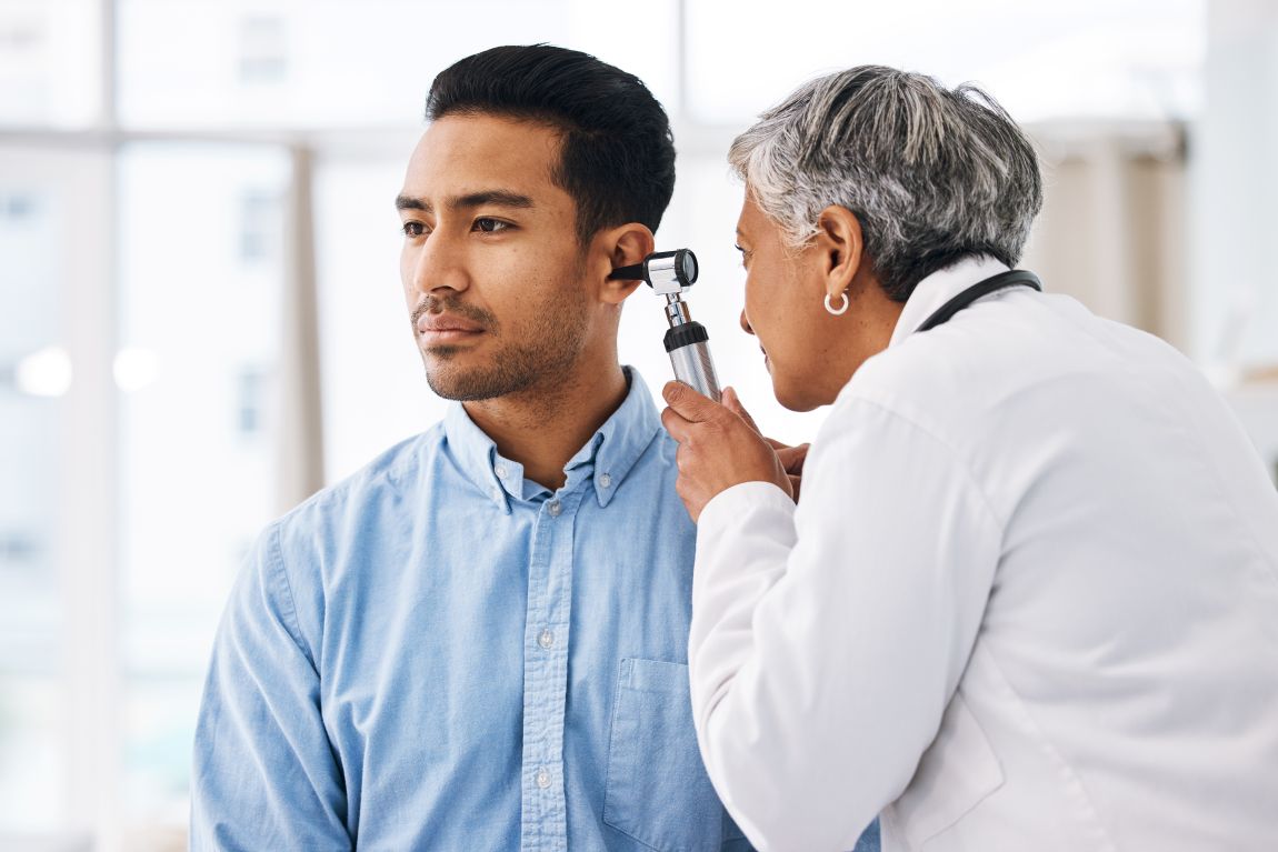 ENT diagnosing acoustic neuroma physician using otoscope to check for acoustic neuromas