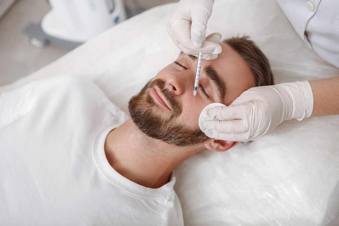 Juvederm Filler Candidate man laying down receiving juvederm injection in cheek